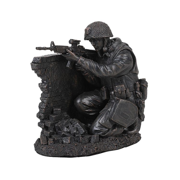 Statue of a soldier with a rifle crouching behind a wall.