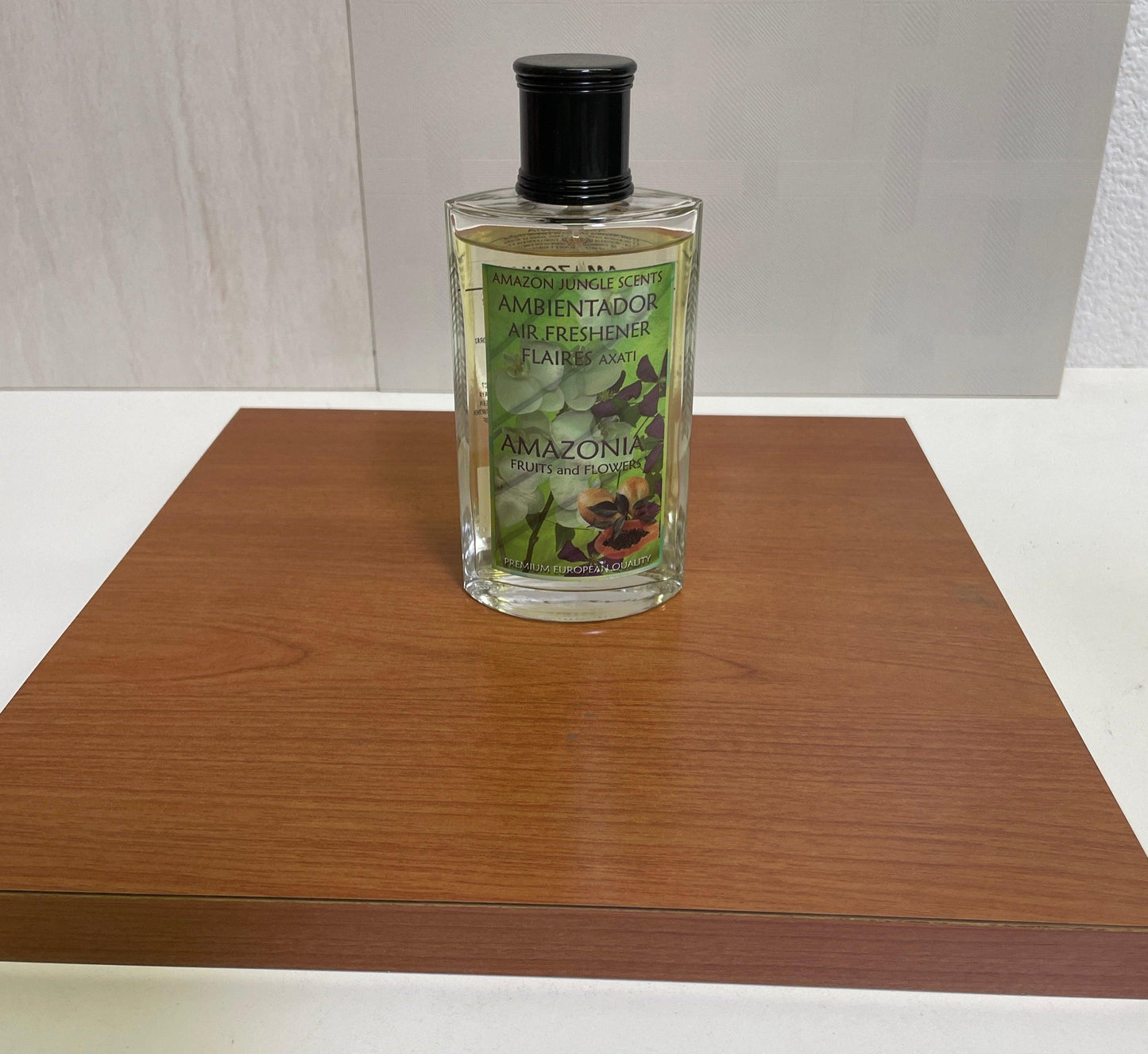 Amazonia air freshener bottle with fruits and flowers label on a wooden surface