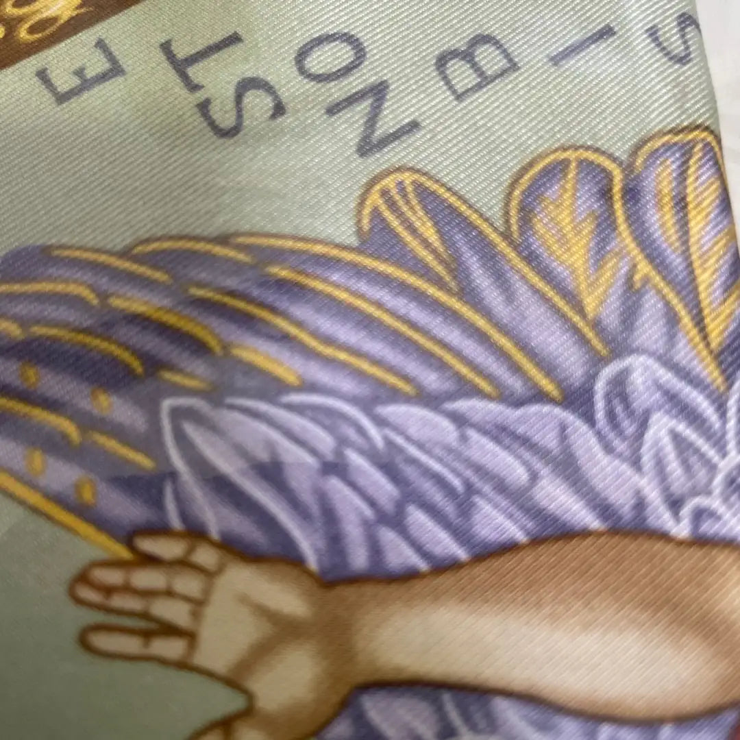 Close-up of a fabric with angel wing and text on a green background