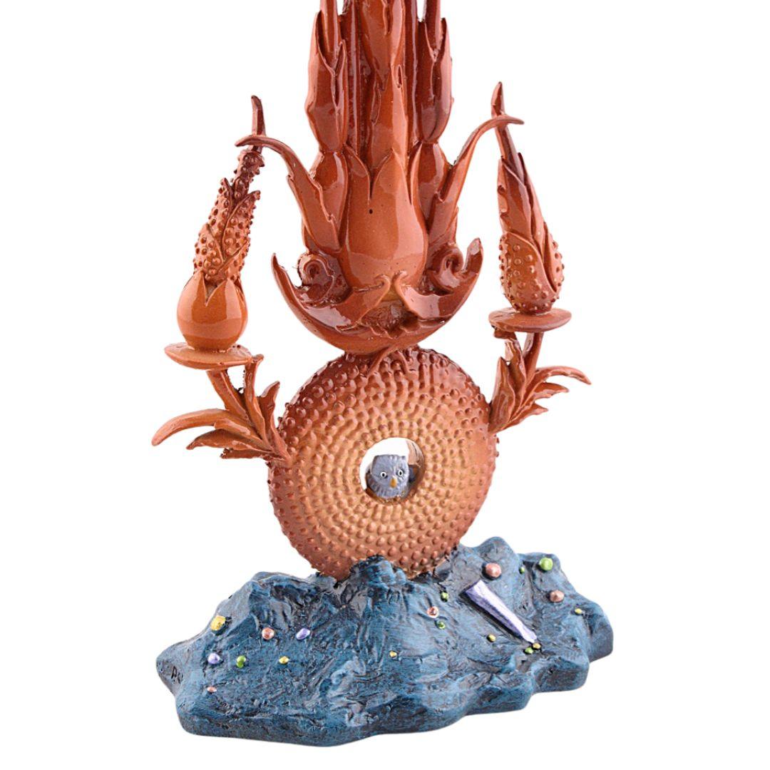 Surreal Bosch-inspired ceramic fountain sculpture with orange details on a blue textured base