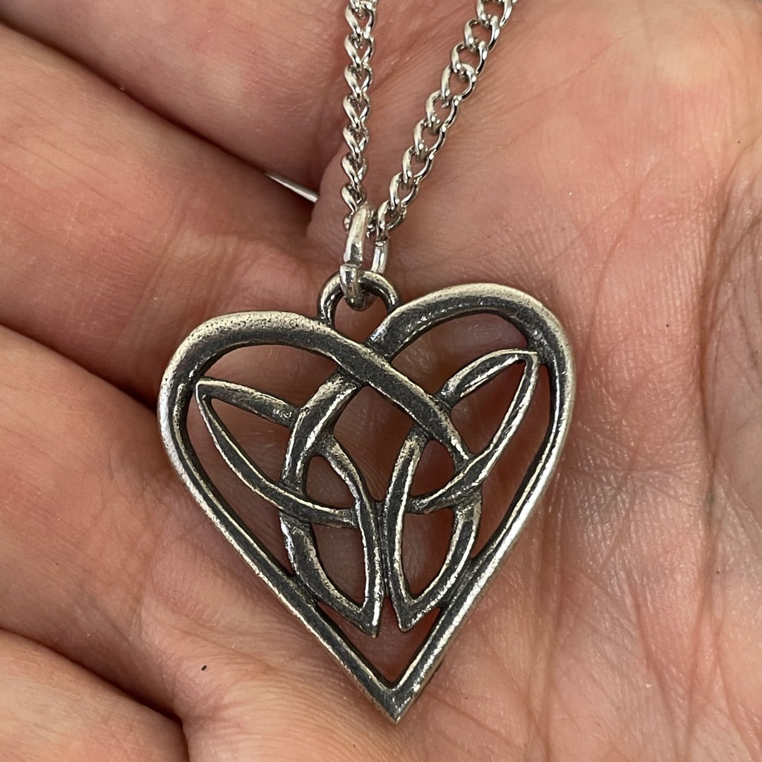 Heart pendant in pewter made from celtic knot show in  a hand for scale