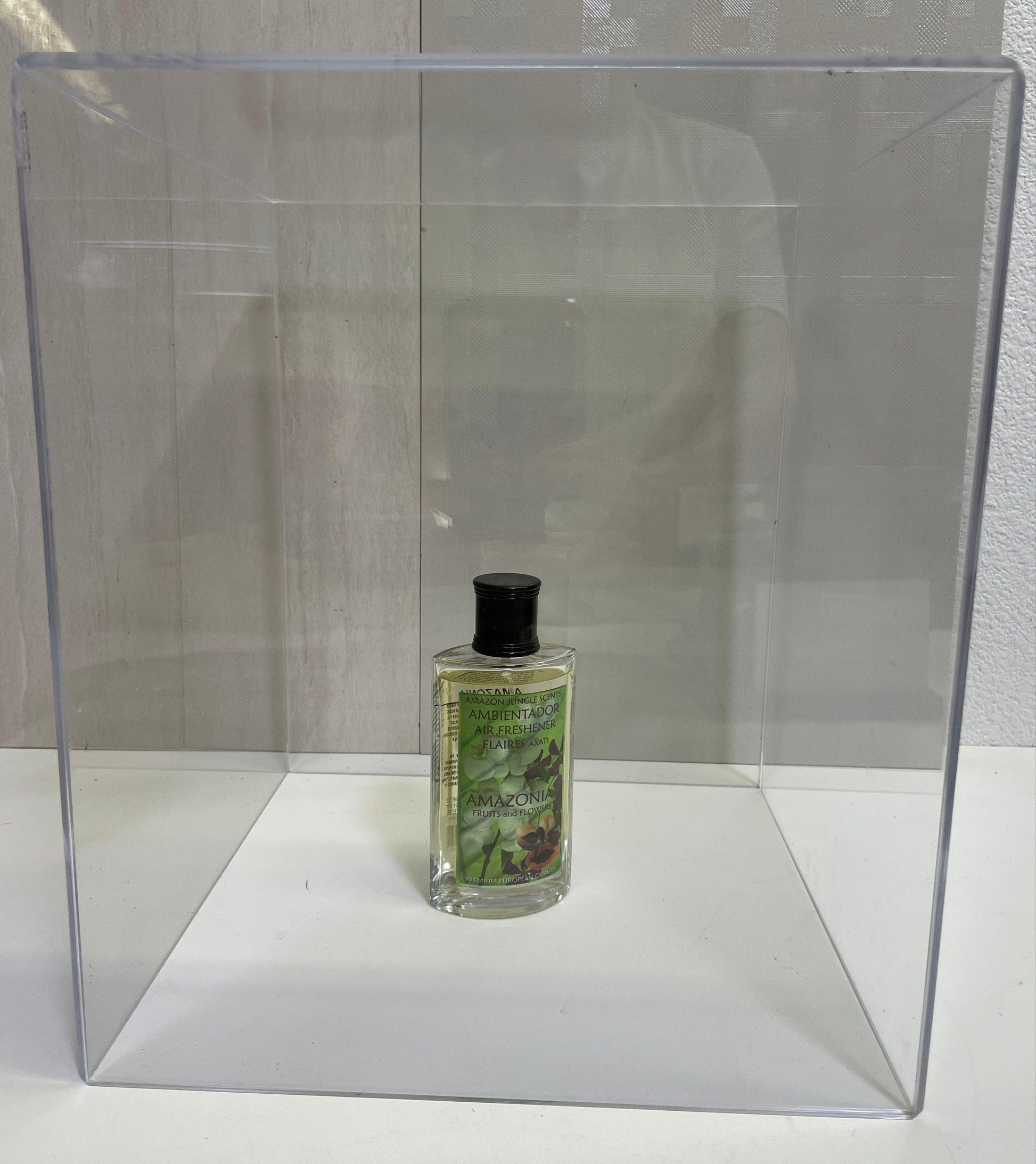 Amazonia air freshener bottle with green label inside a clear display box on a white surface
