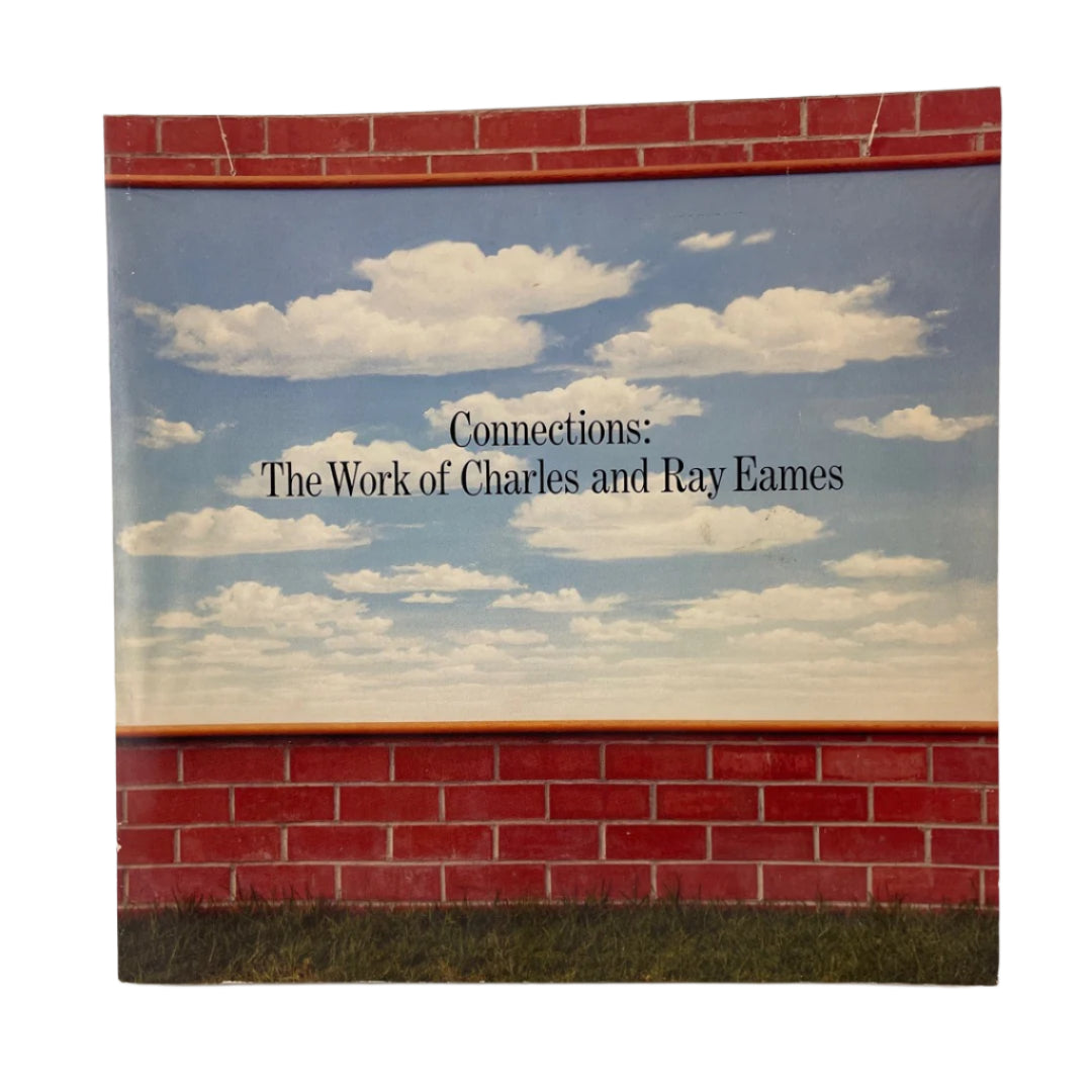 Book cover with a red brick wall and blue sky design, featuring 'Connections: The Work of Charles and Ray Eames'.