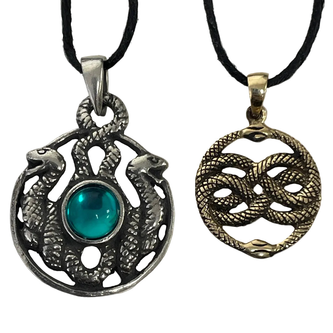Two snake-themed pendants on black cords, one silver-toned with a central turquoise stone and the other gold-toned