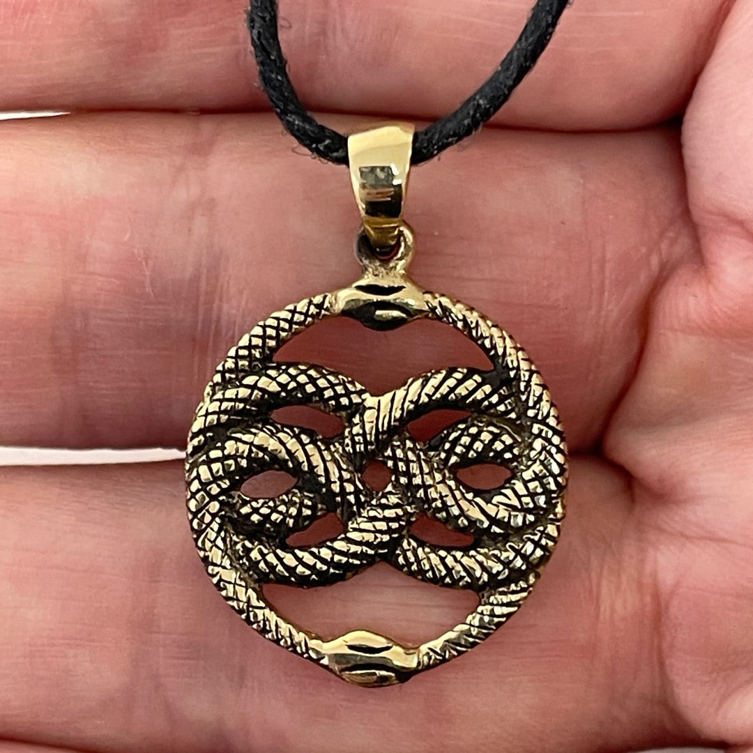 Close up of scaled snake texture on bronze ouroboros pendant