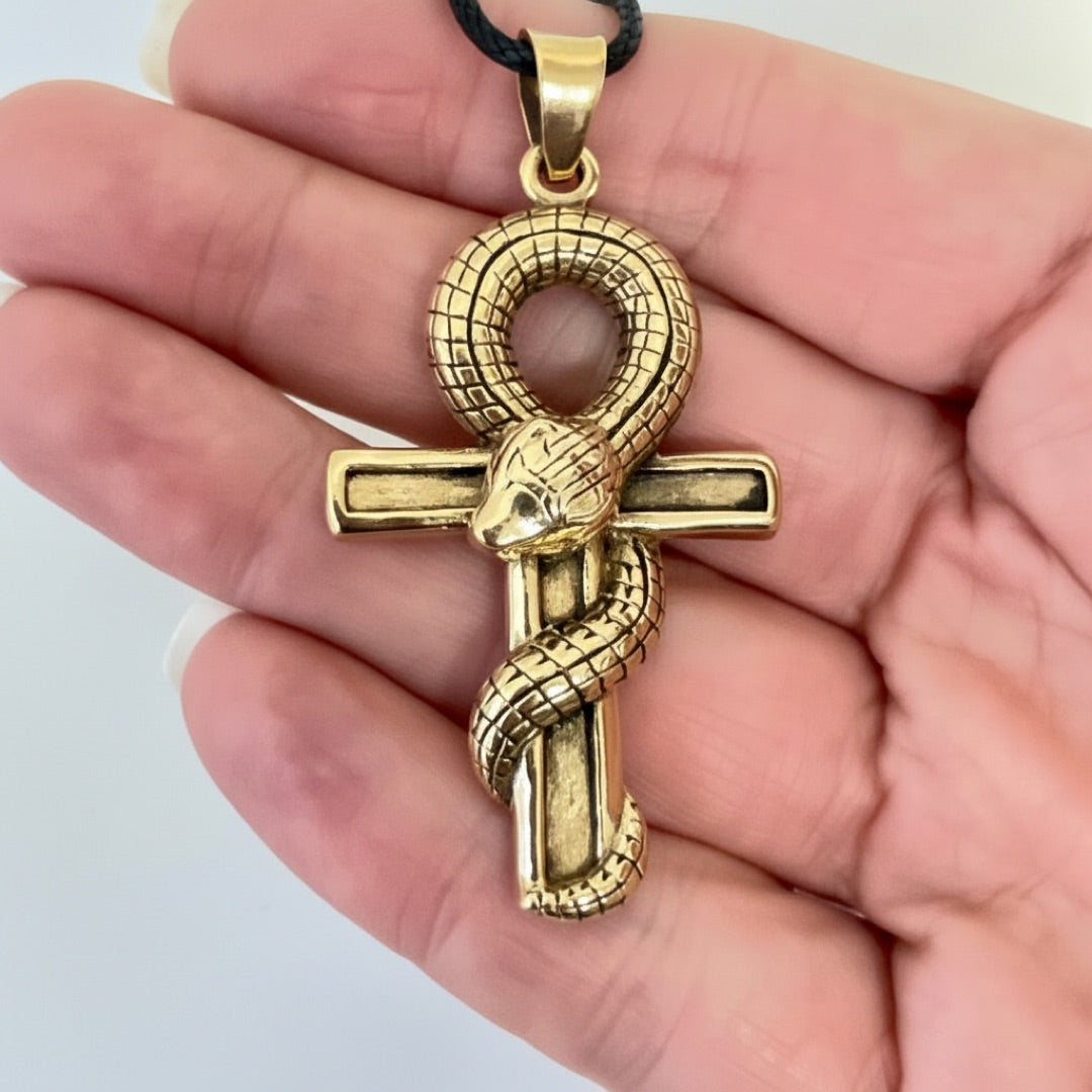 Bronze ankh and snake pendant shown for scale against a hand