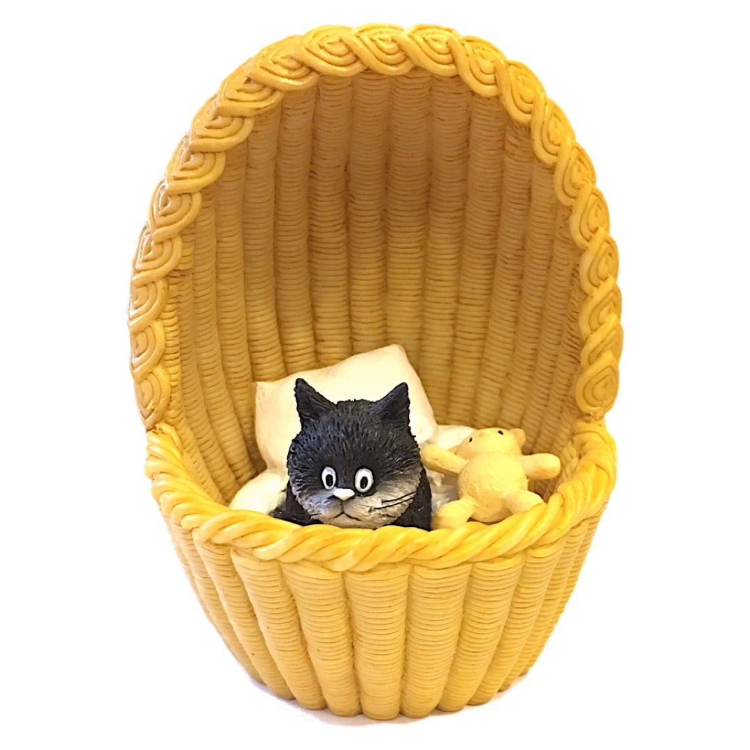 A yellow woven basket-style chair with a rope-tied front, holding a small black cat figurine and a beige plush toy on a white background.