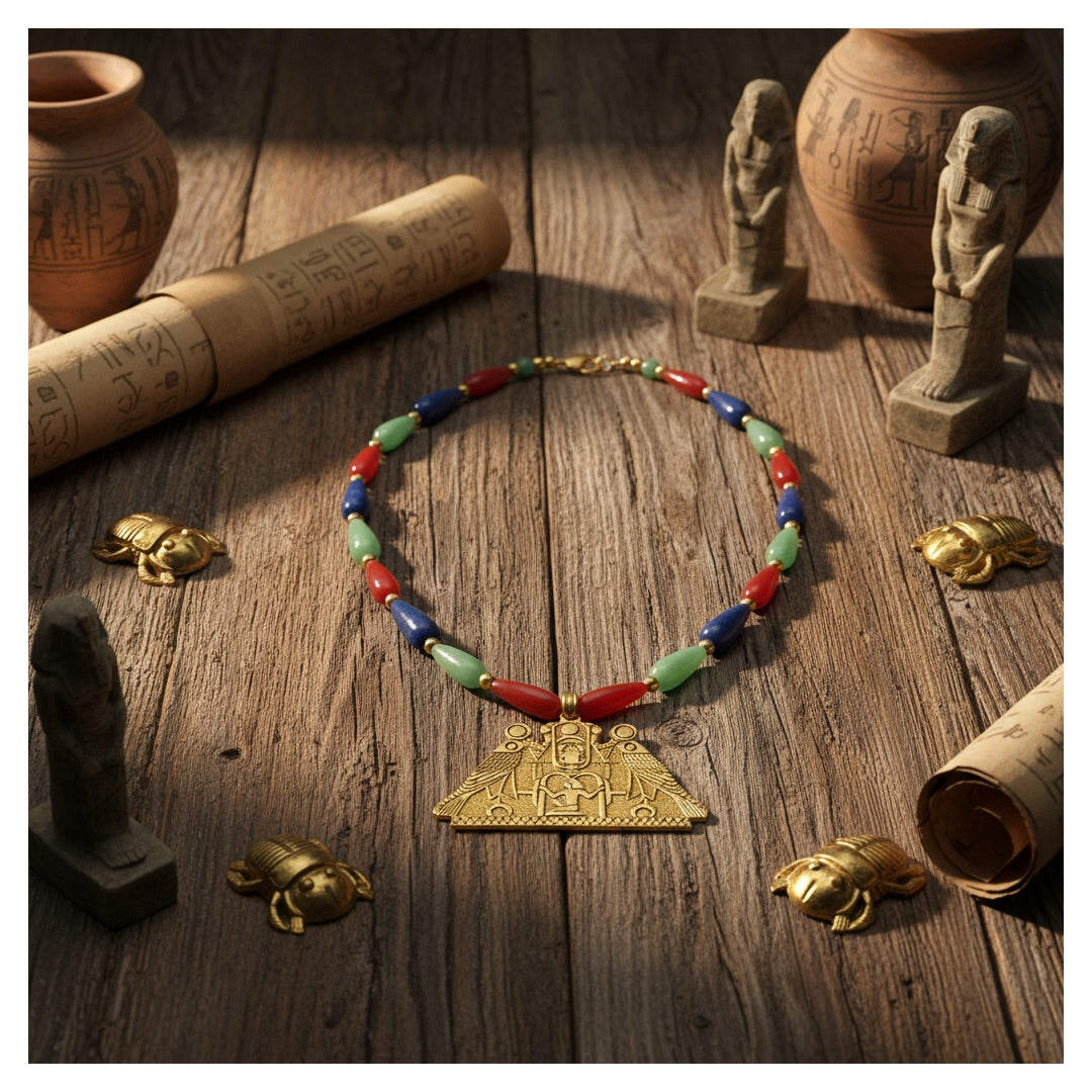Egyptian bead necklace with Horus pendant, museum replica of Ramses II on table