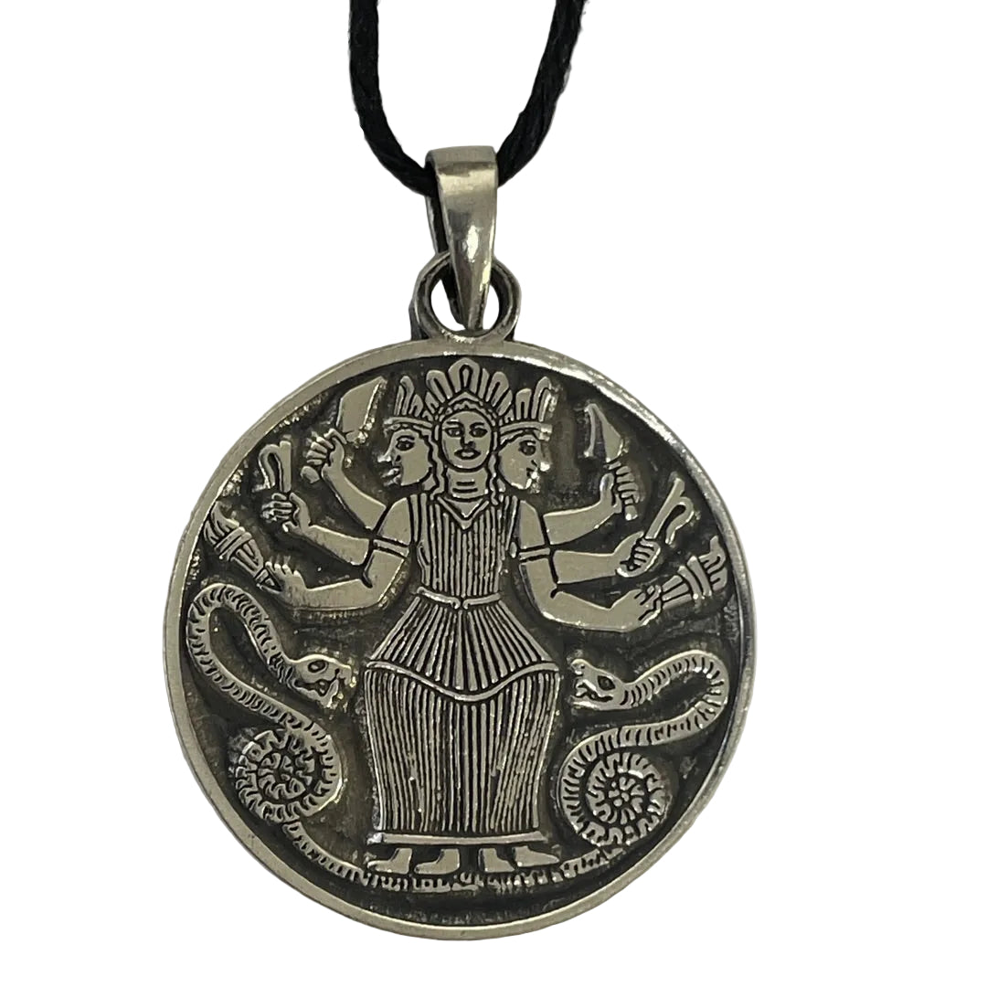 A round silver-toned pendant necklace featuring an embossed multi-armed goddess design with snakes at her sides, suspended from a black cord on a plain light background.