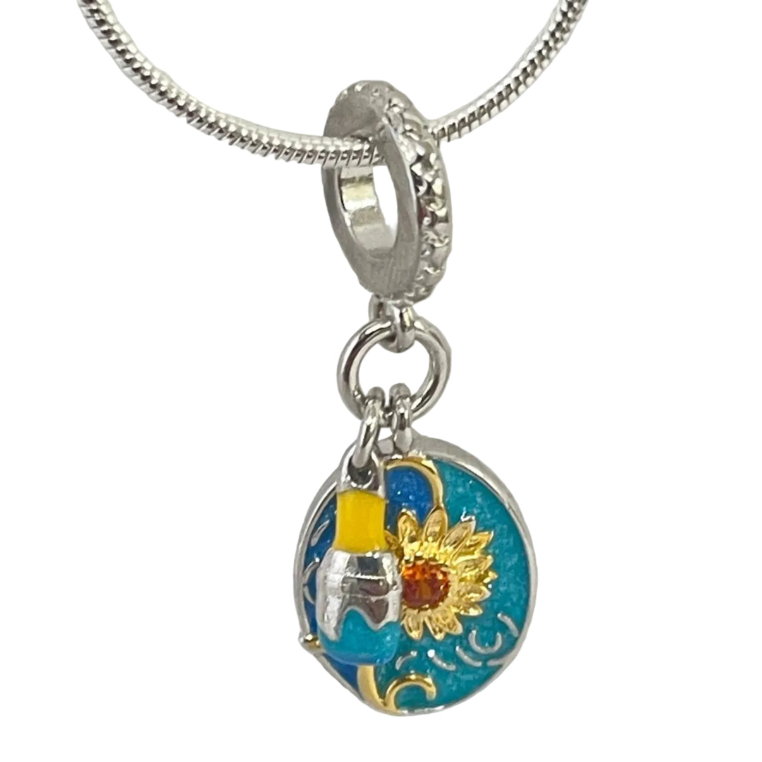 Museum jewelry charm featuring sunflower and miniature artist brush