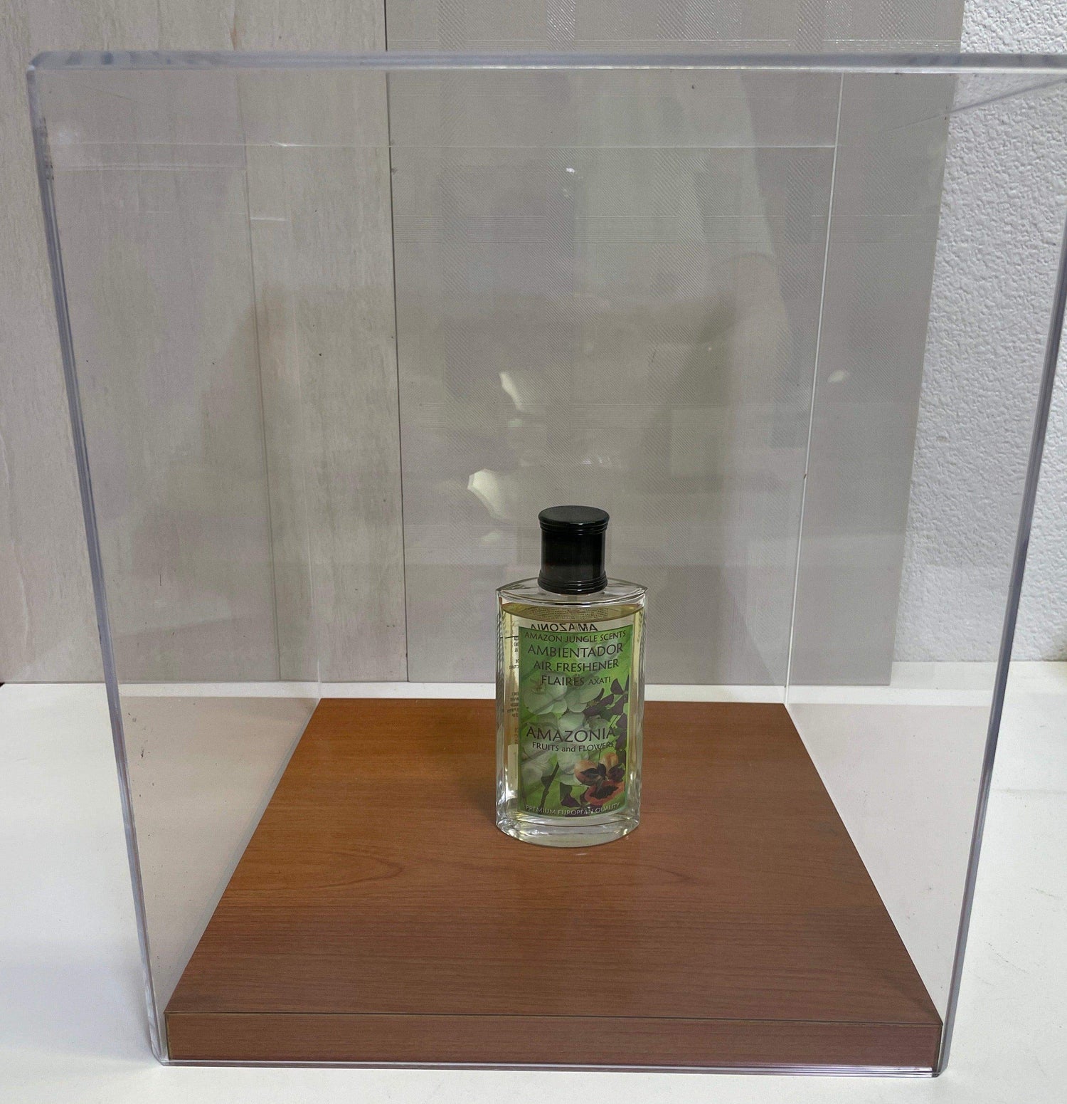 Amazonia air freshener bottle on wood display under clear acrylic case