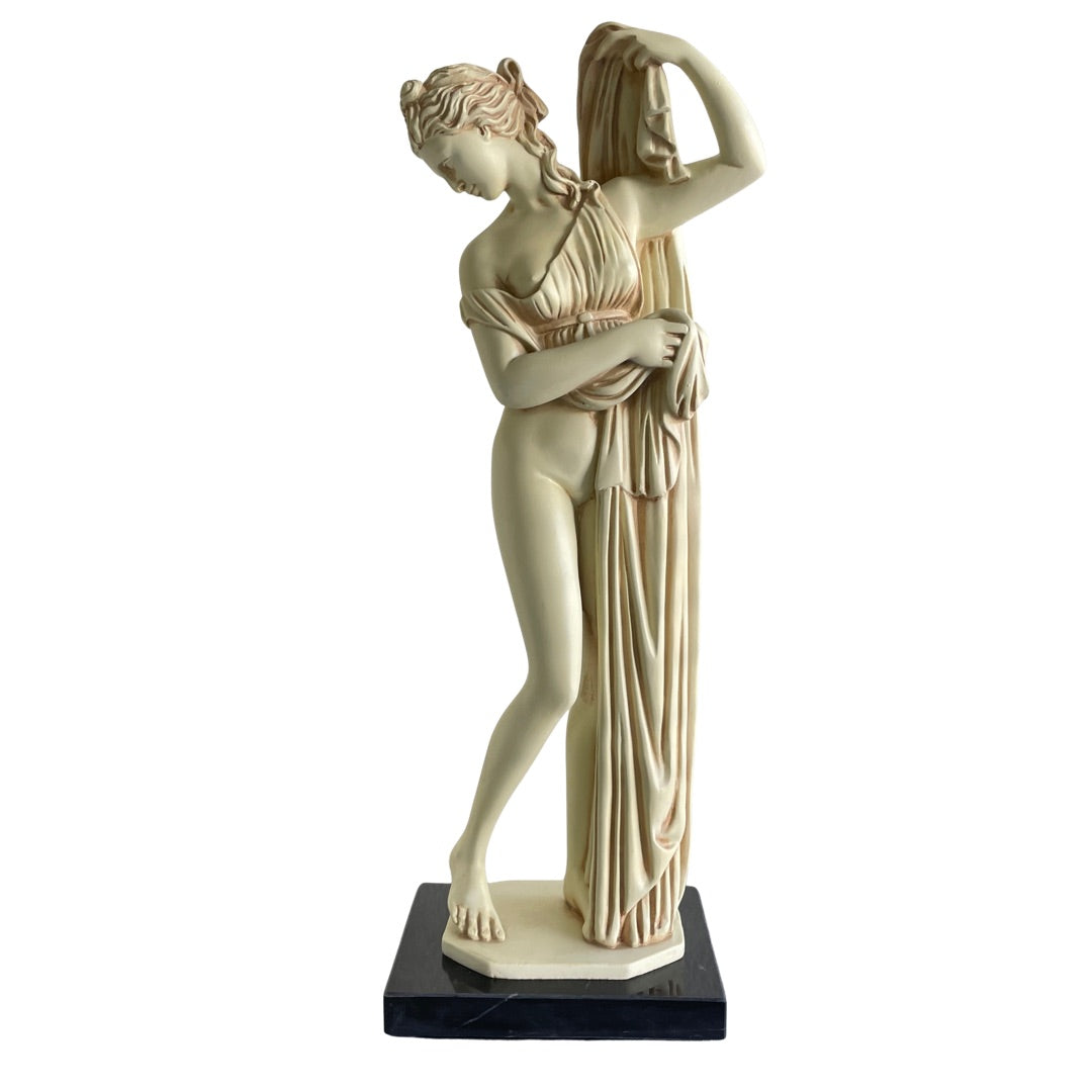 Aphrodite Kallipygos statue on a black marble base, front view