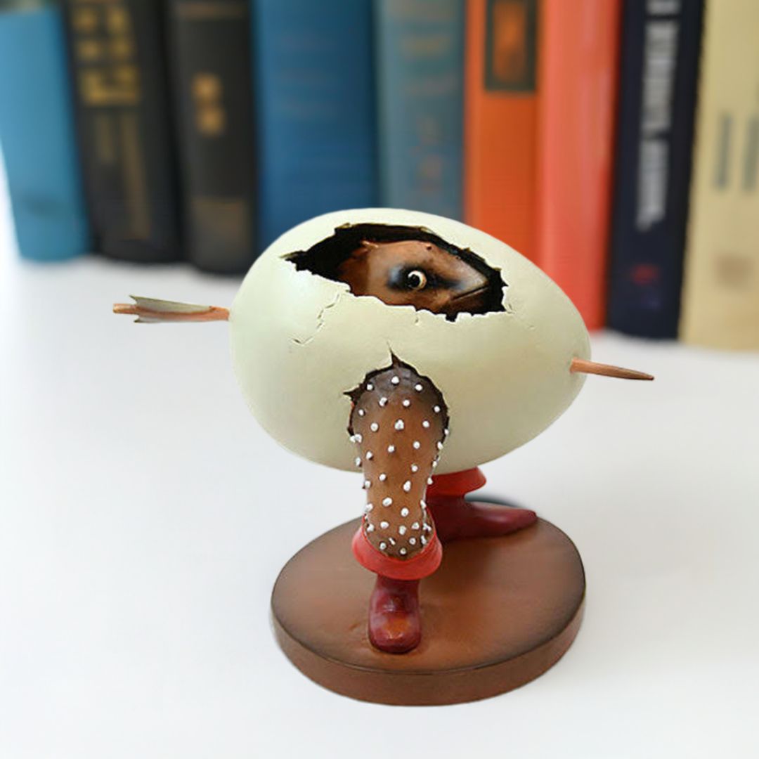 Figurine of a creature emerging from an cracked egg with legs and a toothpick through its middle by Hieronymus Bosch.