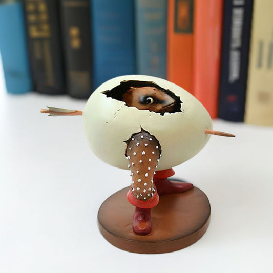Figurine of a creature emerging from an cracked egg with legs and a toothpick through its middle by Hieronymus Bosch.