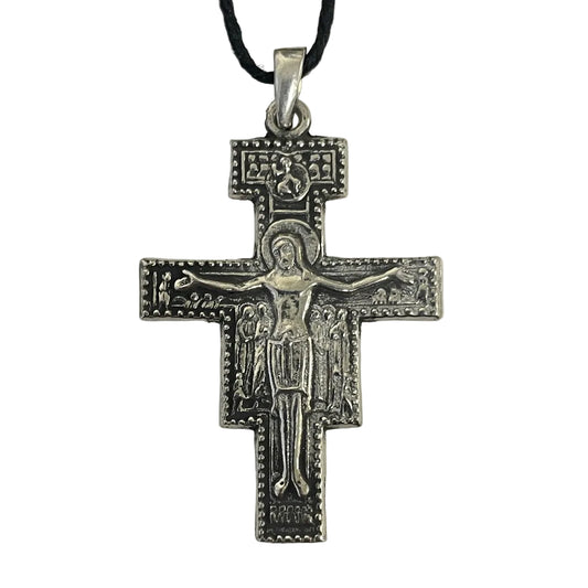 A silver-toned Orthodox Christian cross pendant featuring a detailed depiction of Jesus Christ on the cross, hanging from a black cord against a plain light background.