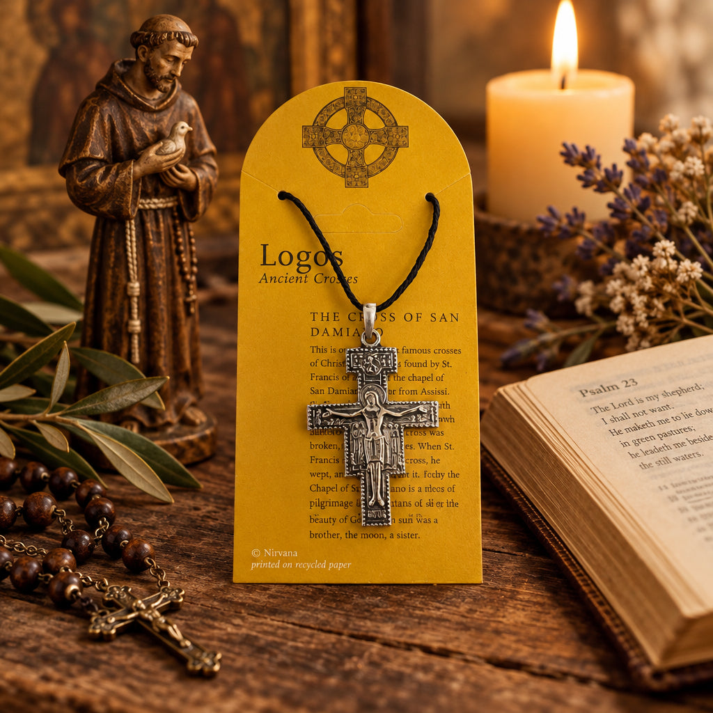 A silver-toned wooden cross pendant featuring a detailed depiction of Jesus Christ on the cross, hanging from a black cord. The cord is attached to a yellow arched display card labeled 'Logos Ancient Crosses' with text about 'The Cross of San Damino'.