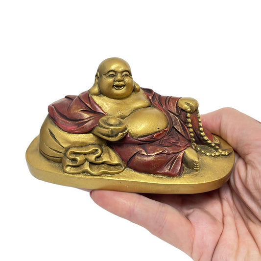Budai statue held in a hand to show its small size