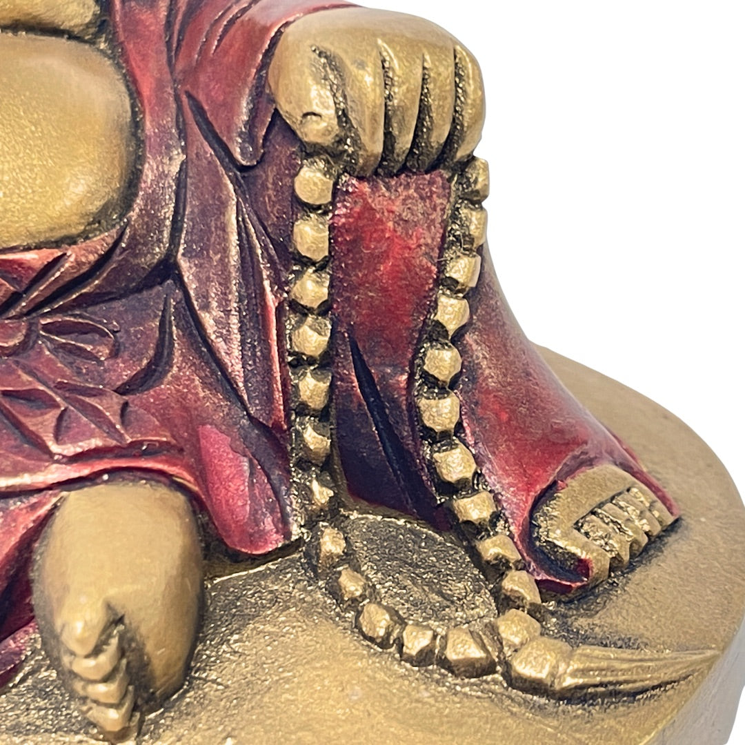 Detail of prayer beads and robe hem on the gold reclining Budai figurine