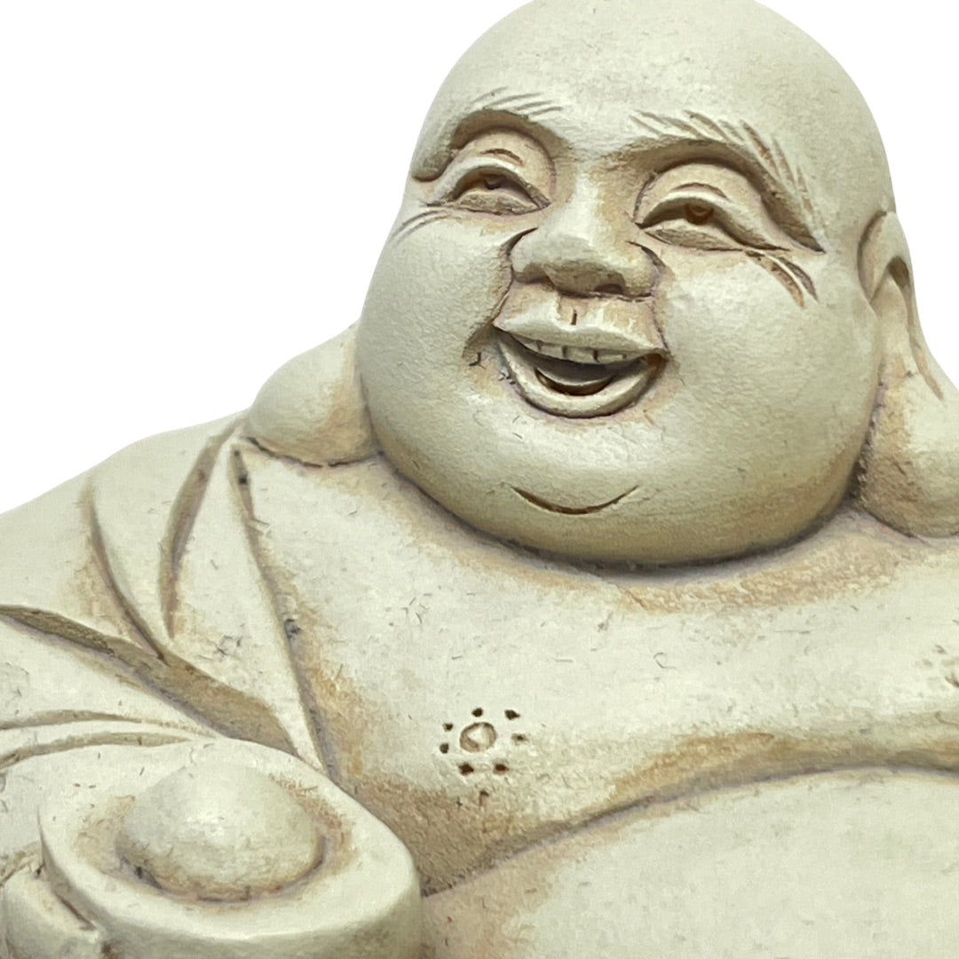 Close-up of the laughing face on the antique white Budai figurine
