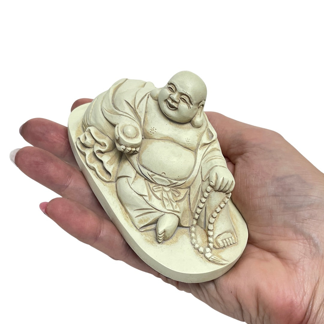 Antique white Budai statue held in a hand to show its small size