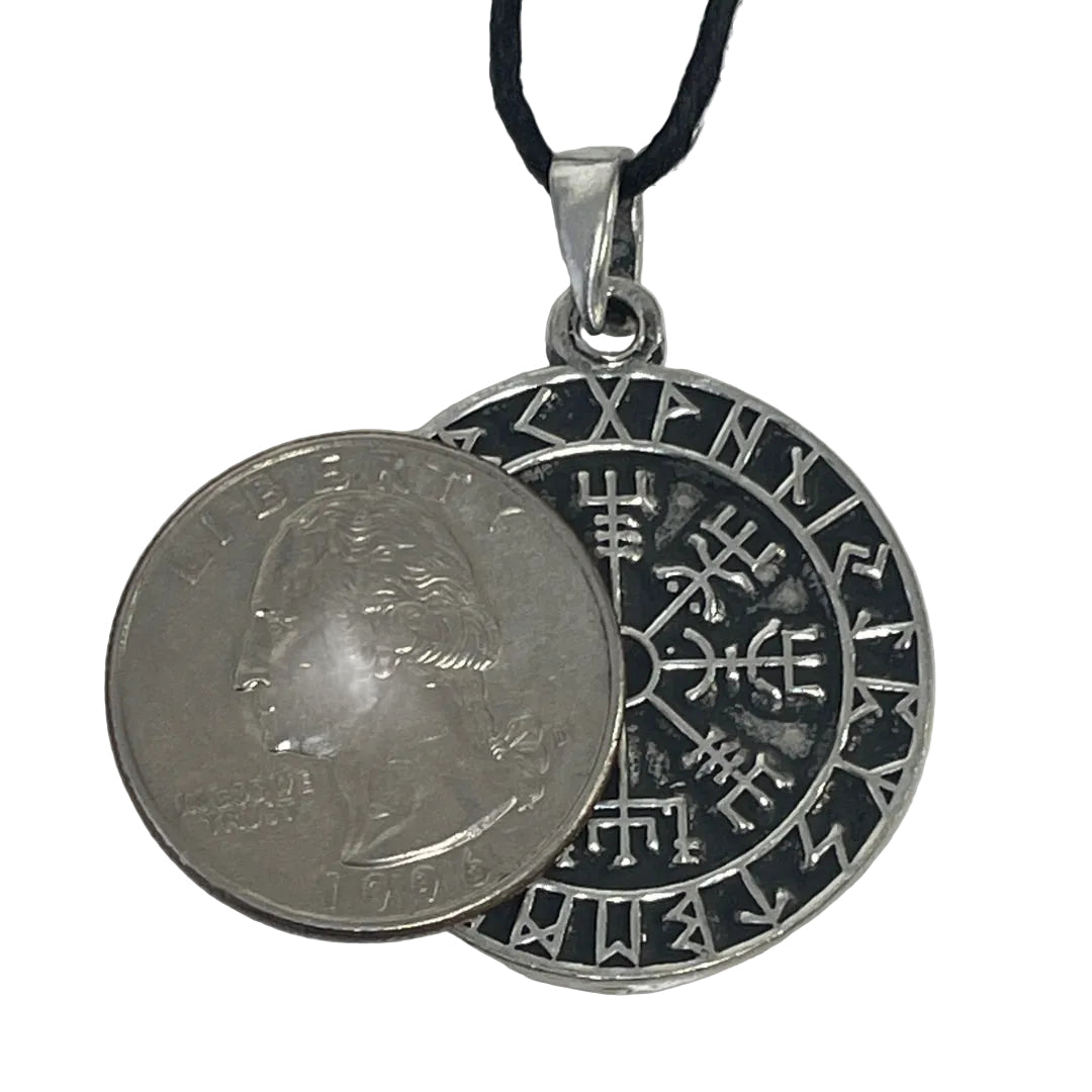 A silver-toned circular helm of awe rune pendant necklace with a black cord, shown next to a U.S. quarter