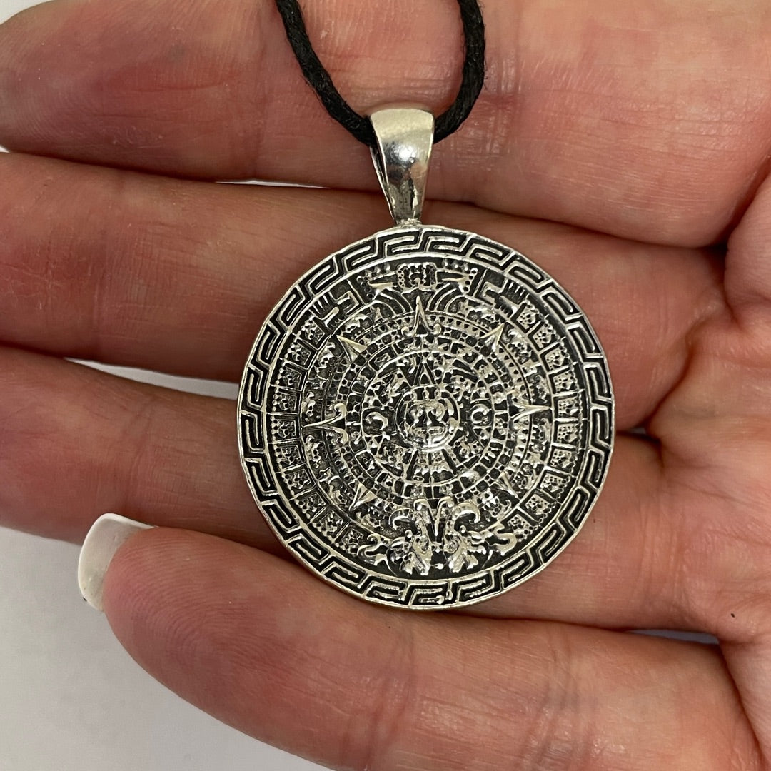 Close view of the concentric carved rings and central face of the Aztec Sun Stone pendant