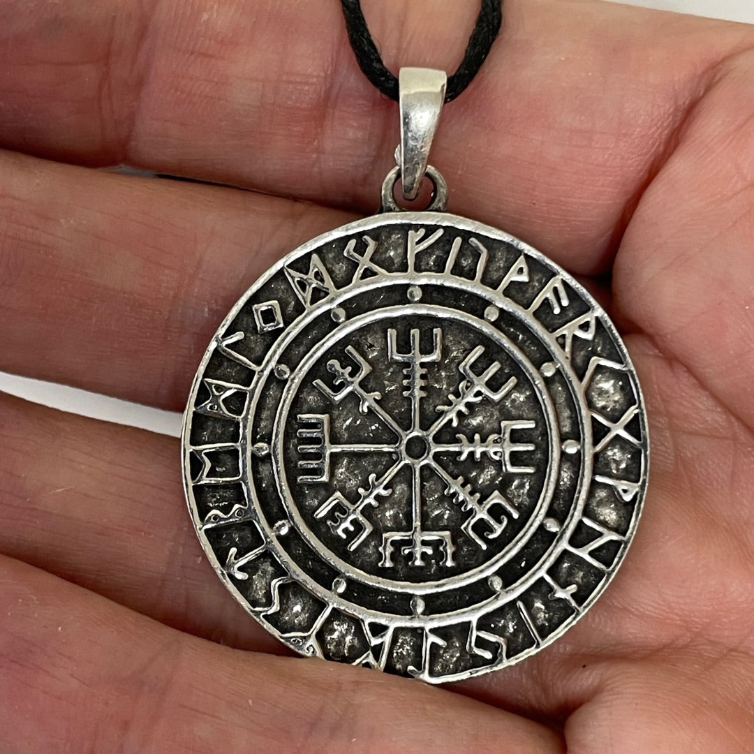 Vegvisir pewter pendant shown for scale held in a hand