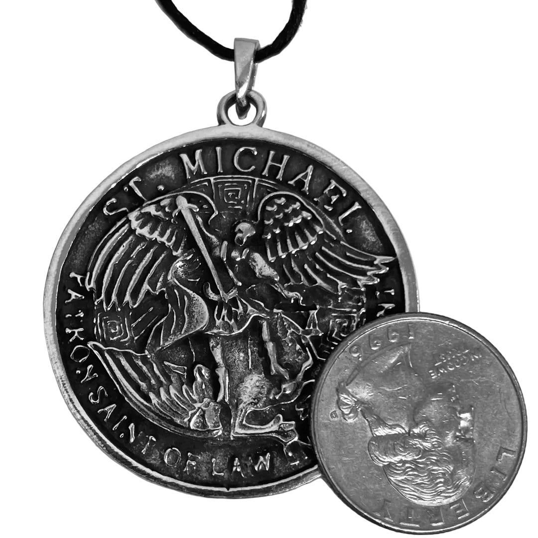 Detail of Archangel Michael pewter pendant for scale next to a quarter