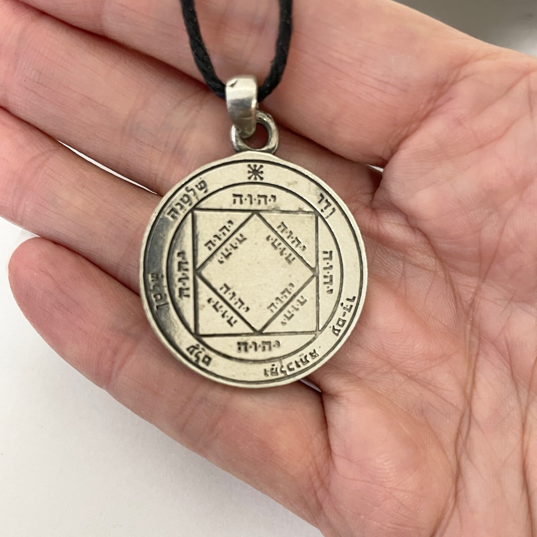 Third Pentacle of the Sun pewter pendant shown for scale in hand