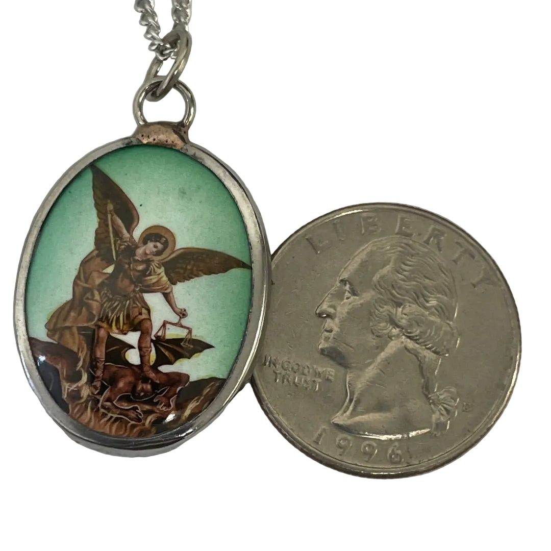 St. Michael ceramic pendant shown for scale next to a quarter