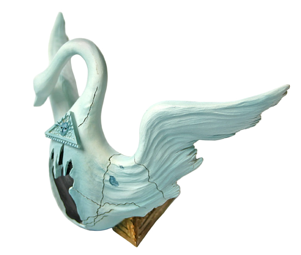 Decorative swan figurine with a cracked surface on a white background