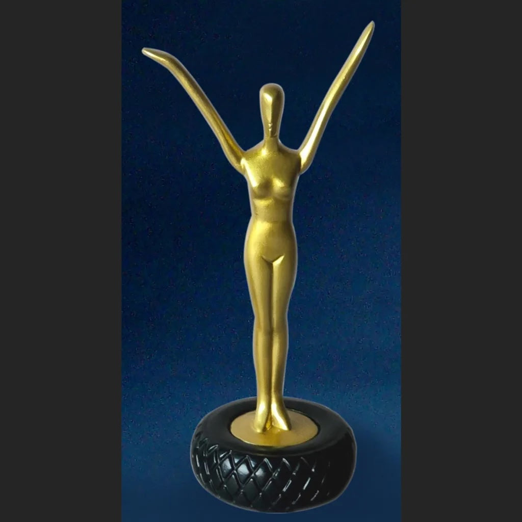 Parastone image of Dali Gold statue of a nude figure on a black base against a blue background