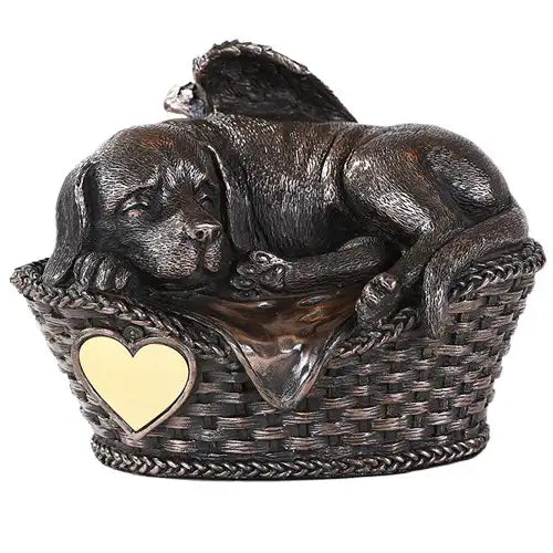 Dog urn with angel wings showing sleeping dog in basket with blanket, bronze finish.